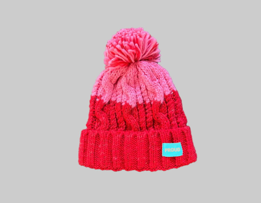 Silky lined pom pom hat in red and pink with proud logo